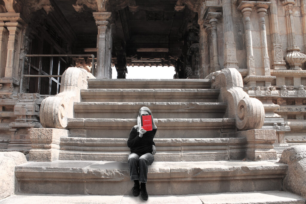 Author Anne Howell, who now has a reimagining of Wuthering Heights,  reading a book about amnesia, on steps.